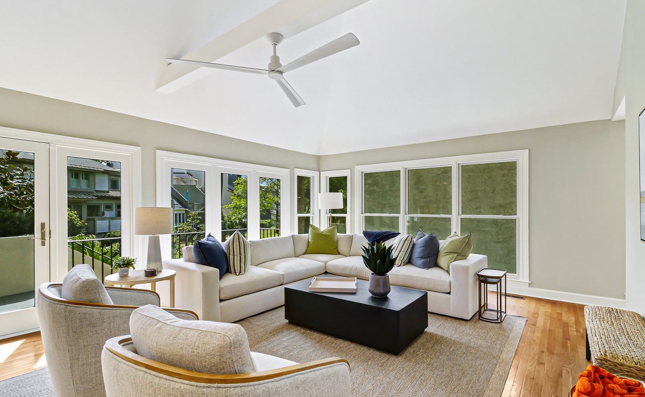 Relax in your bright living room with plush seating, soaring ceilings, and garden views through floor-to-ceiling windows.