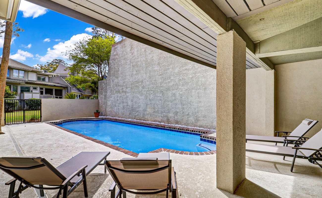 Your private pool oasis awaits beneath a covered patio, perfect for cooling off or lounging poolside in complete privacy.