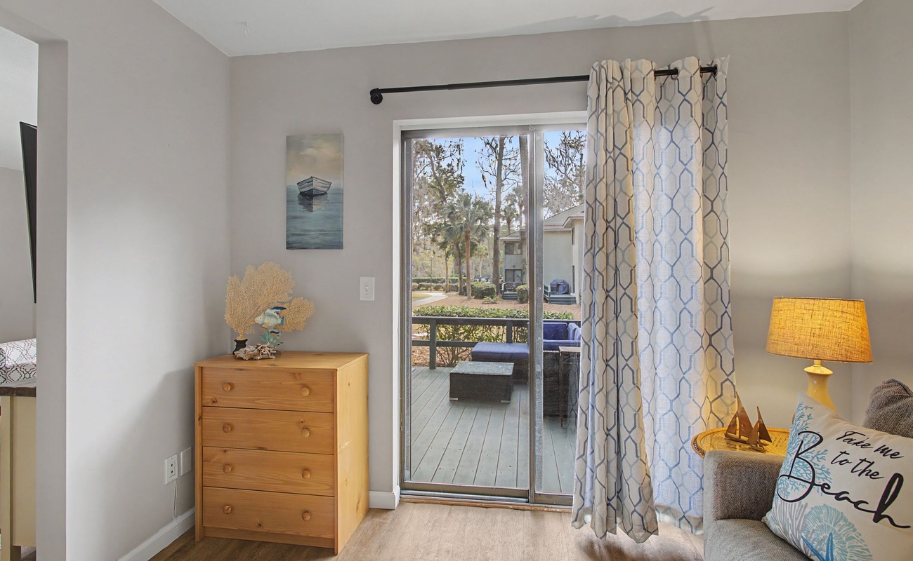 Step onto your private balcony from this bright room, where morning coffee meets peaceful views and coastal-inspired decor creates your perfect retreat.