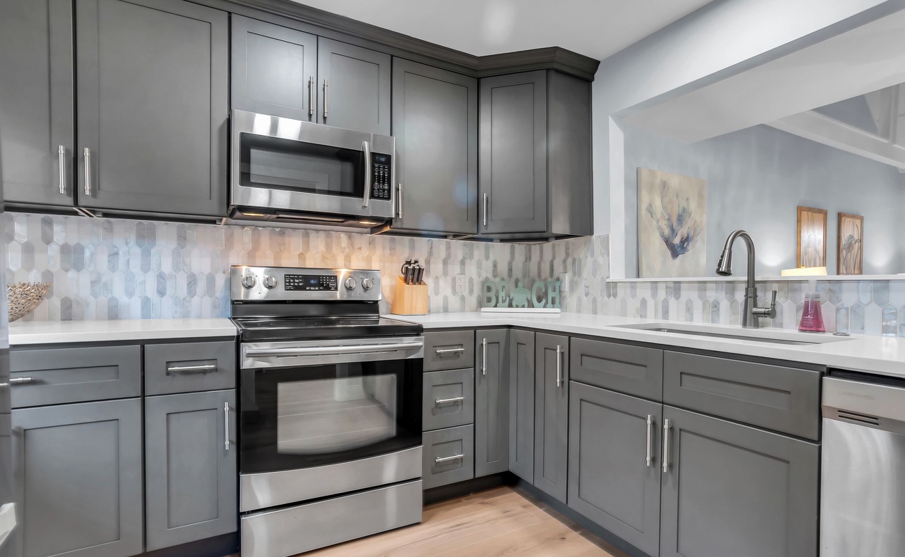 You'll love preparing meals in this sleek modern kitchen with stainless steel appliances, stylish gray cabinetry, and beautiful geometric backsplash.