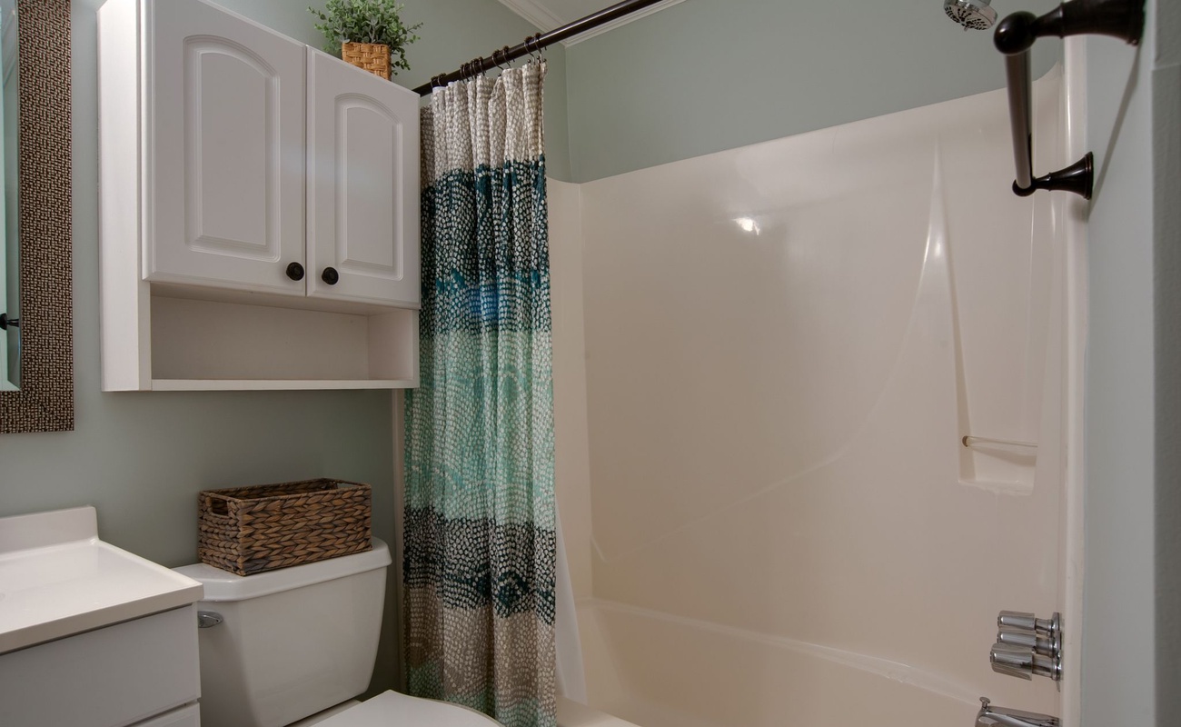 Your private bathroom offers a refreshing shower-tub combo with thoughtful storage and charming coastal touches.