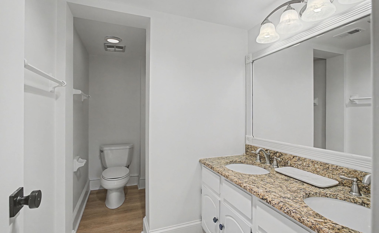 Step into your private bathroom sanctuary with granite countertops, dual vanity sinks, and a peaceful separate toilet alcove.
