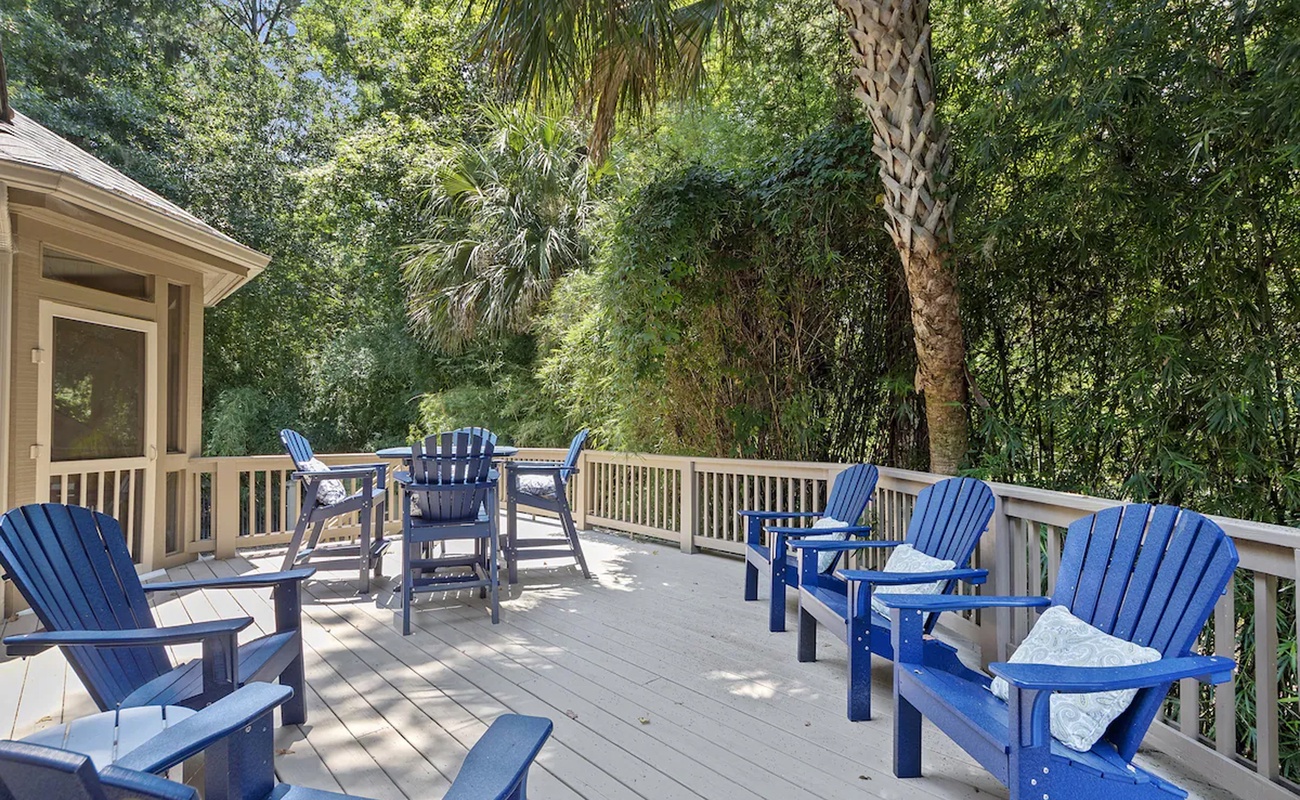 Sink into comfy Adirondack chairs on this spacious deck, where dappled sunlight filters through lush trees for perfect morning coffee moments.