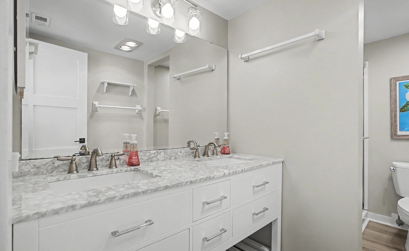 Step into your spa-like bathroom with dual vanities, marble countertops, and warm lighting for your morning routine.