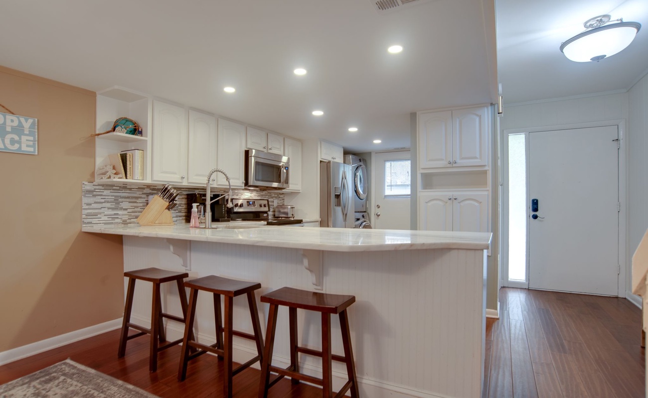 Gather around this bright kitchen island with three bar stools, perfect for morning coffee or casual meals together.