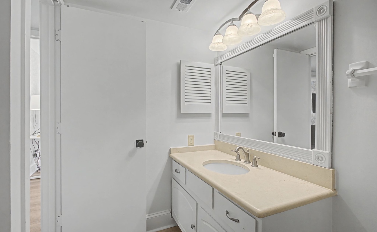 Step into your bright, pristine bathroom featuring elegant vanity lighting and ample counter space for your morning routine.