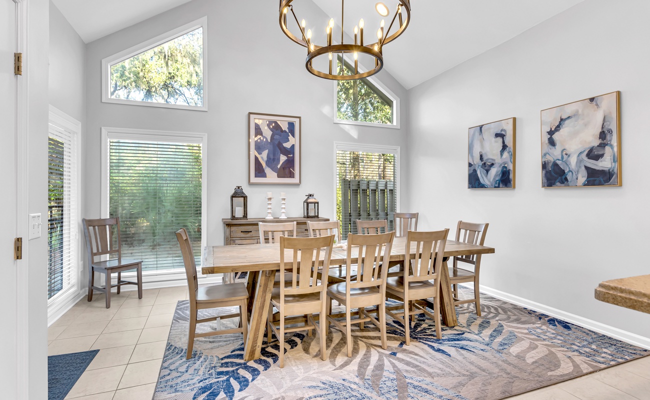 Gather around this elegant dining table where natural light streams through tall windows, creating the perfect setting for memorable meals together.