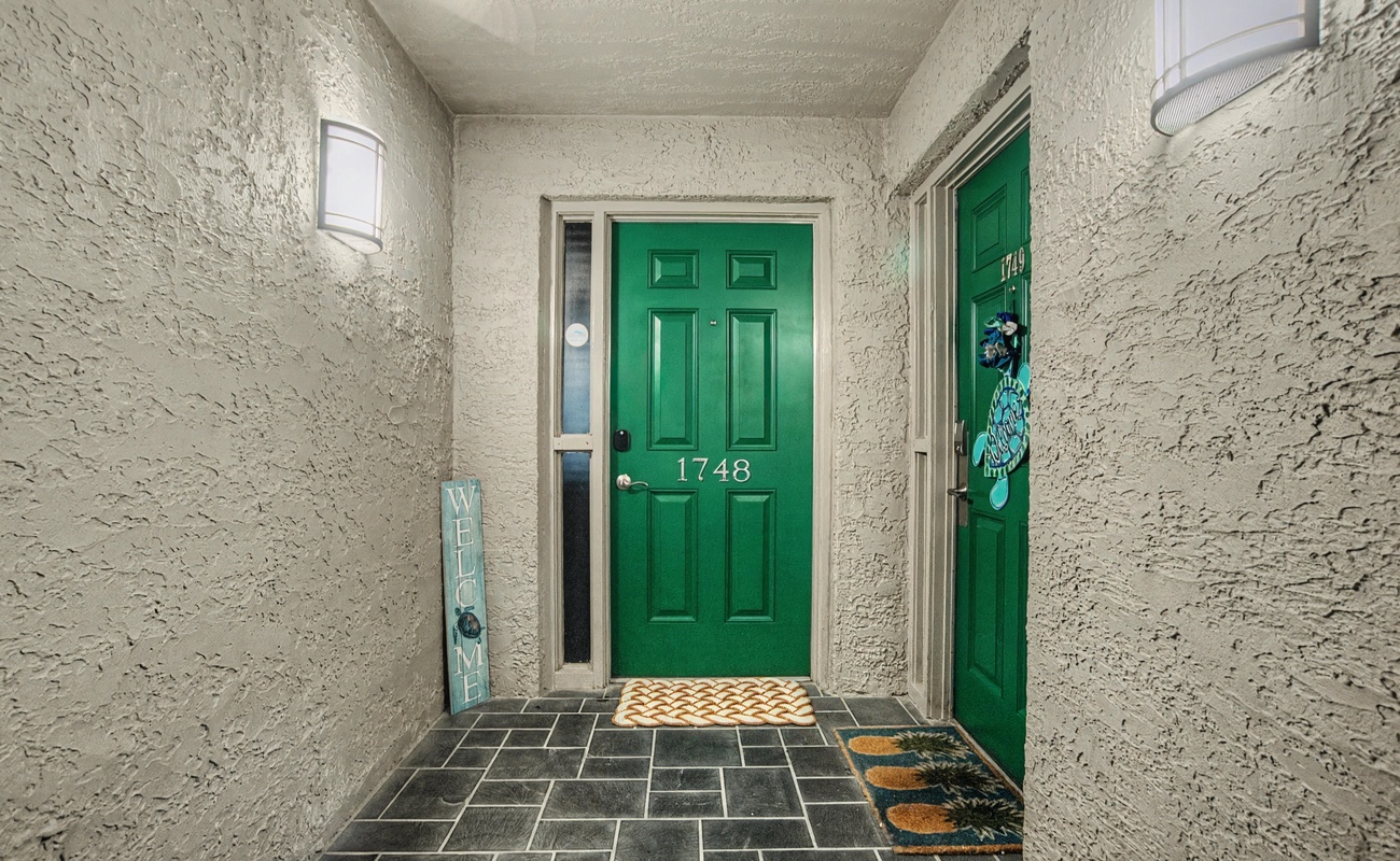 A welcoming entrance with distinctive green doors and charming decorative touches that mark your arrival at this comfortable retreat.