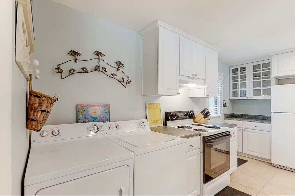 Your fully-equipped kitchen and laundry combo features white appliances, ample cabinet storage, and thoughtful coastal touches that make meal prep a breeze.