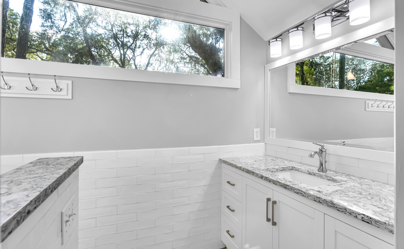 Refresh in your bright bathroom with marble counters and peaceful garden views through large windows.