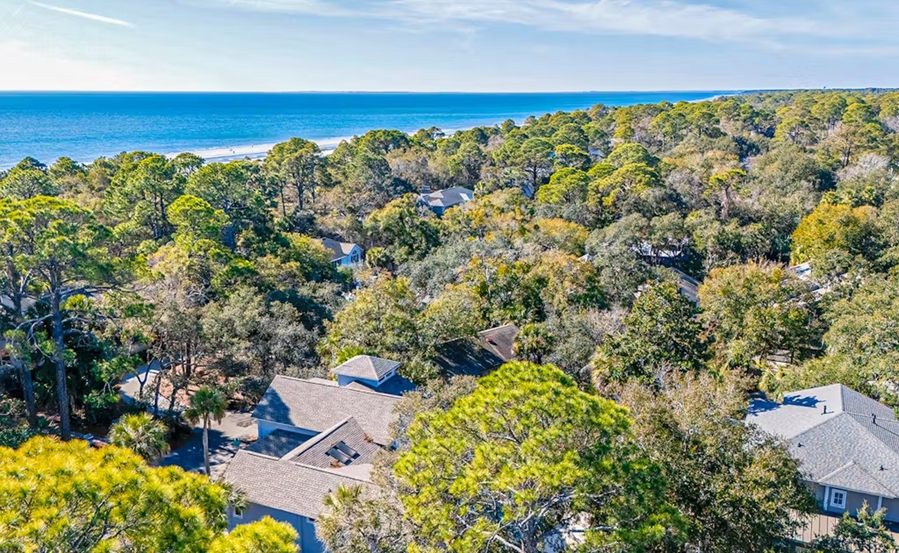 Coastal retreat nestled among mature trees, just steps from pristine beach access.