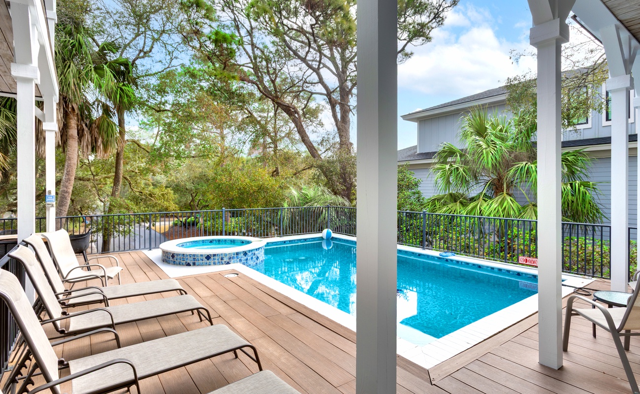 Unwind on your private deck where loungers await poolside, while the hot tub beckons for evening soaks under tropical palms.