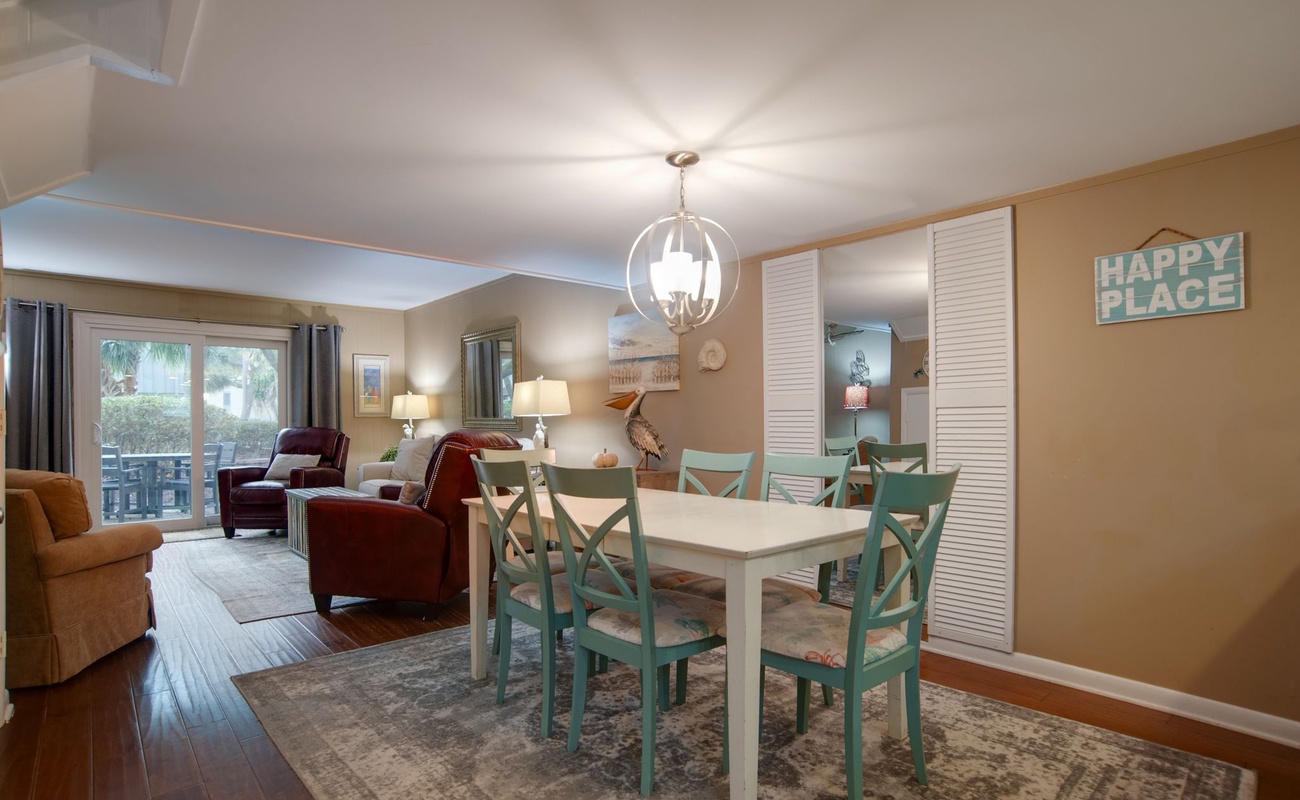 Gather around your charming dining table where warm lighting and coastal colors create perfect moments for shared meals and conversations.