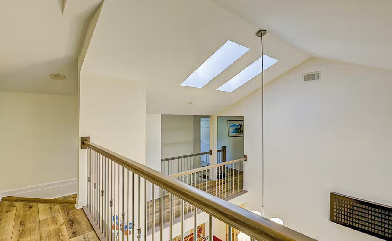Natural light floods through skylights in this airy upstairs landing, creating a bright, welcoming space as you move between floors.