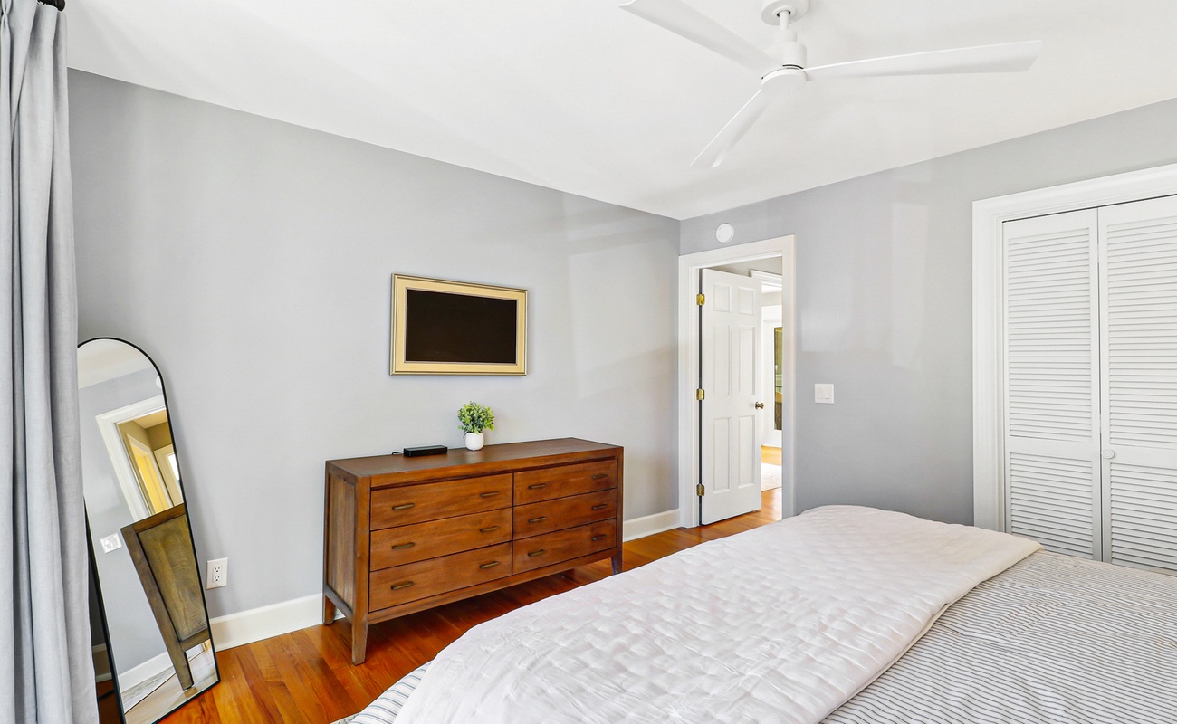 Your peaceful bedroom features warm hardwood floors, elegant furniture, and a ceiling fan to keep you comfortable throughout your stay.