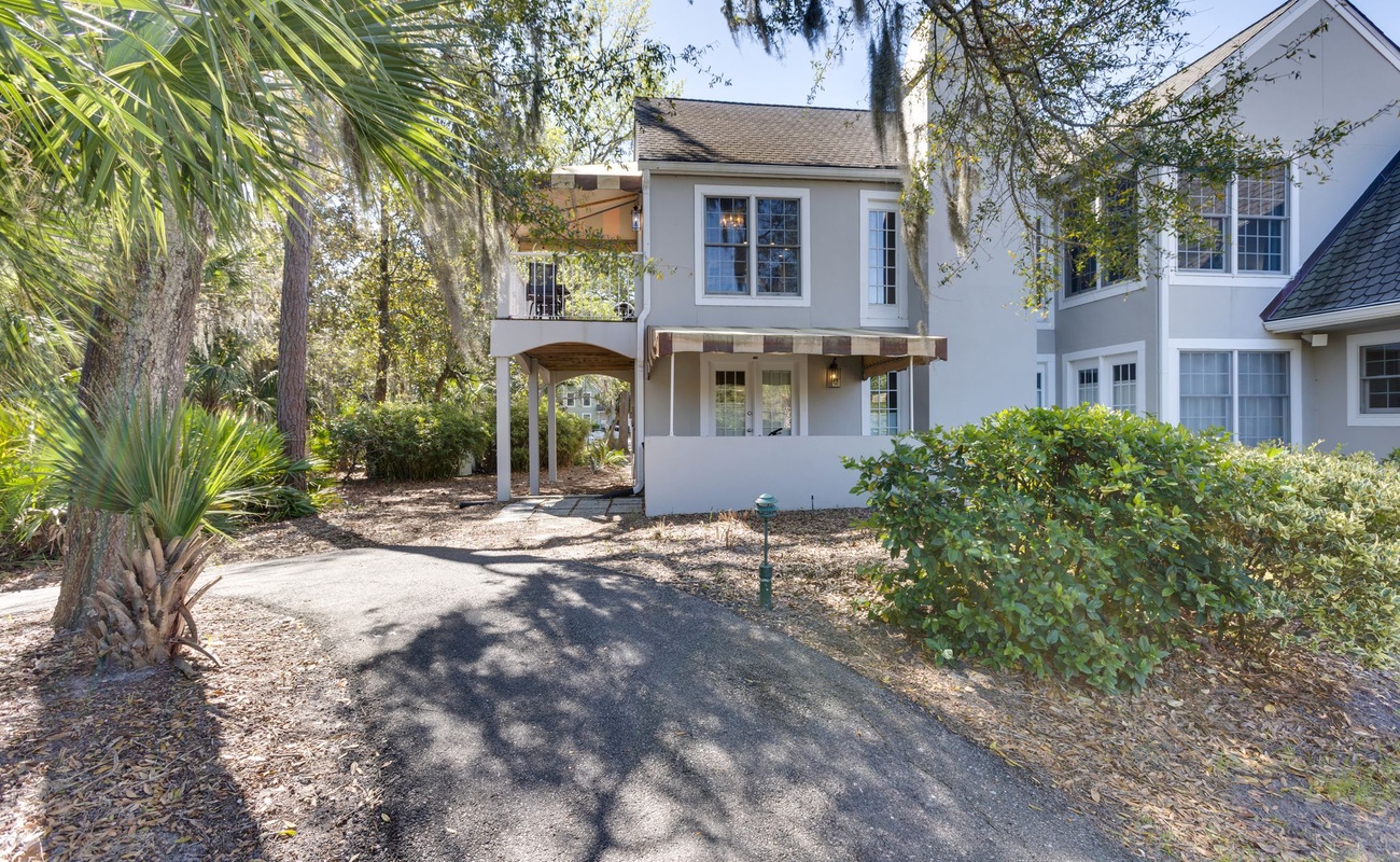 Charming coastal retreat nestled among mature palms and lush landscaping in a peaceful residential setting.