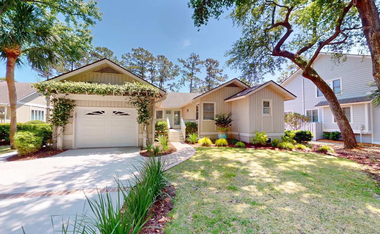 Charming coastal retreat with mature trees and landscaped grounds in a peaceful residential neighborhood.