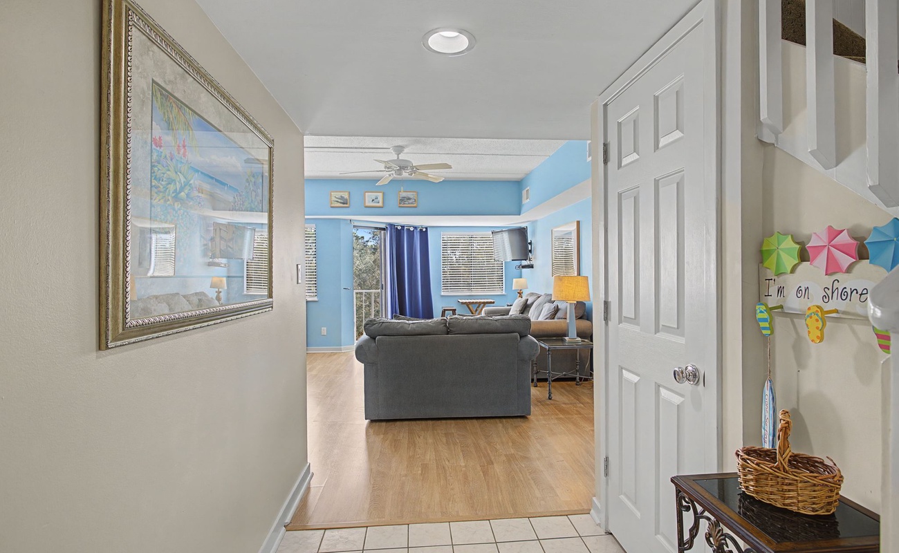 Step into your bright coastal haven where cheerful blue walls and comfortable seating create the perfect space to unwind after beach adventures.