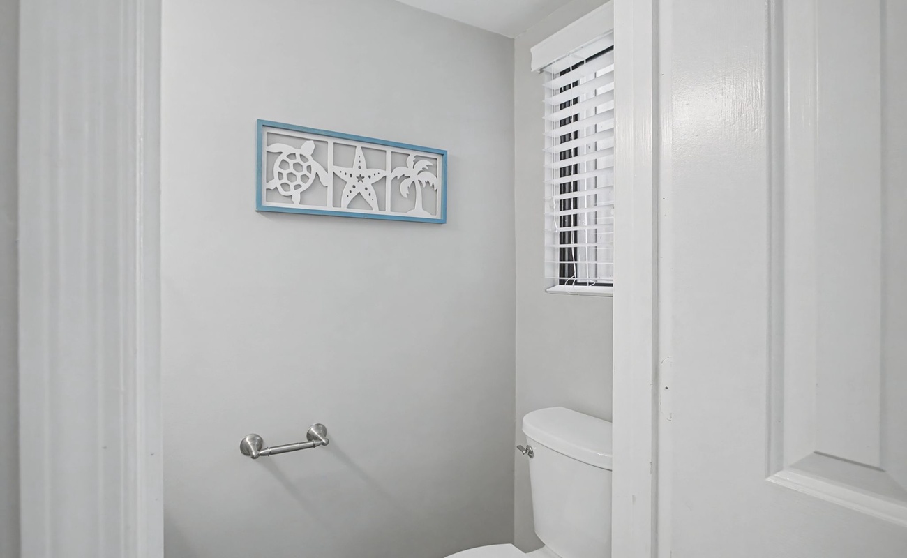 Fresh, clean powder room with nautical accents and private window for your convenience during your stay.