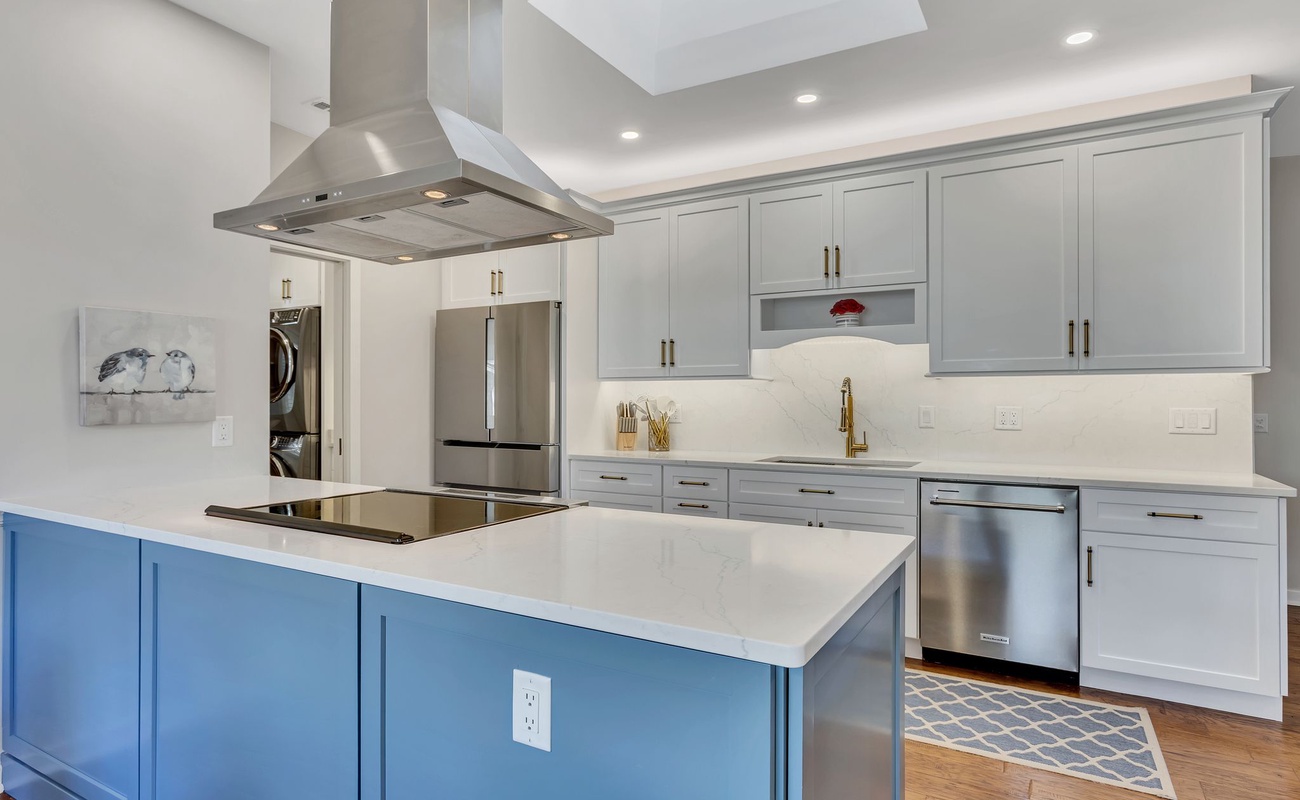 Your gourmet kitchen awaits with gleaming stainless appliances, spacious island, and elegant blue accent cabinetry for memorable culinary moments.