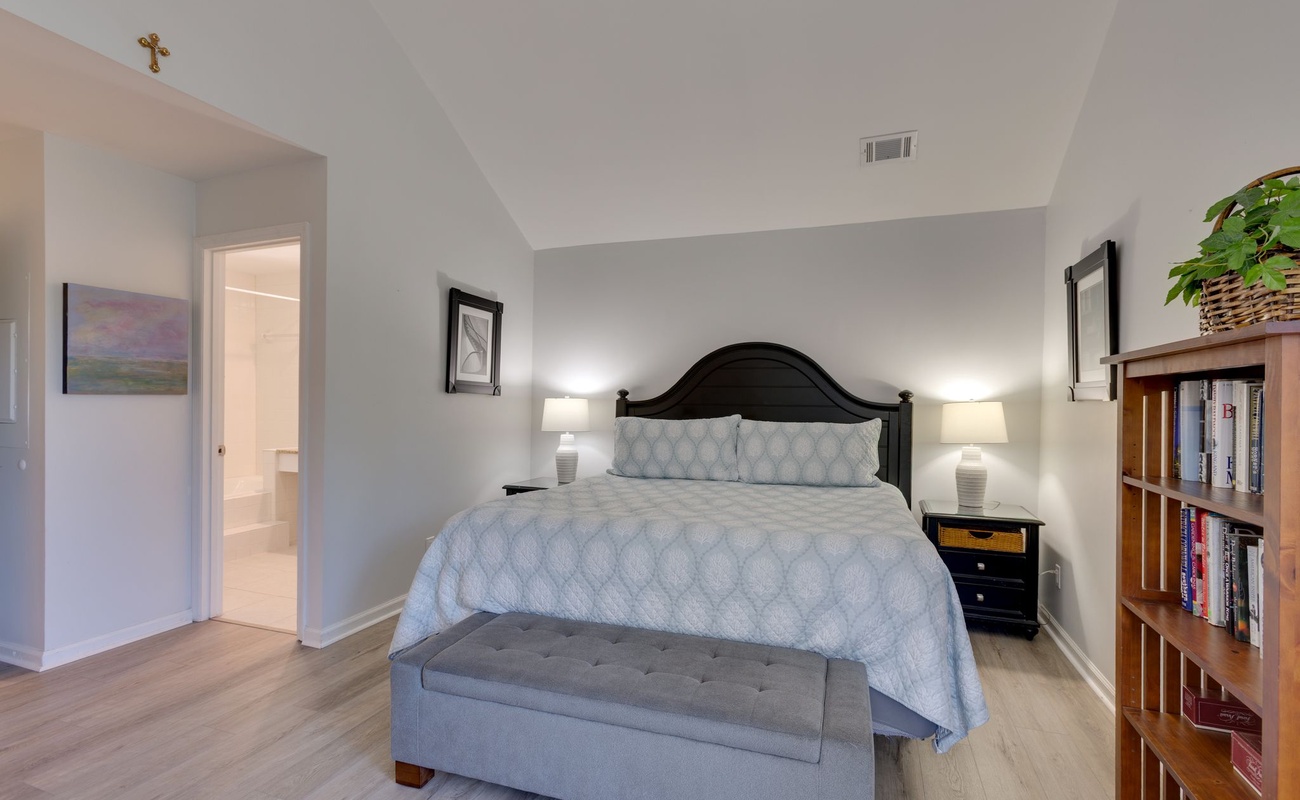 Unwind in your elegantly appointed bedroom with plush bedding, warm lighting, and a cozy reading nook filled with books for peaceful evenings.