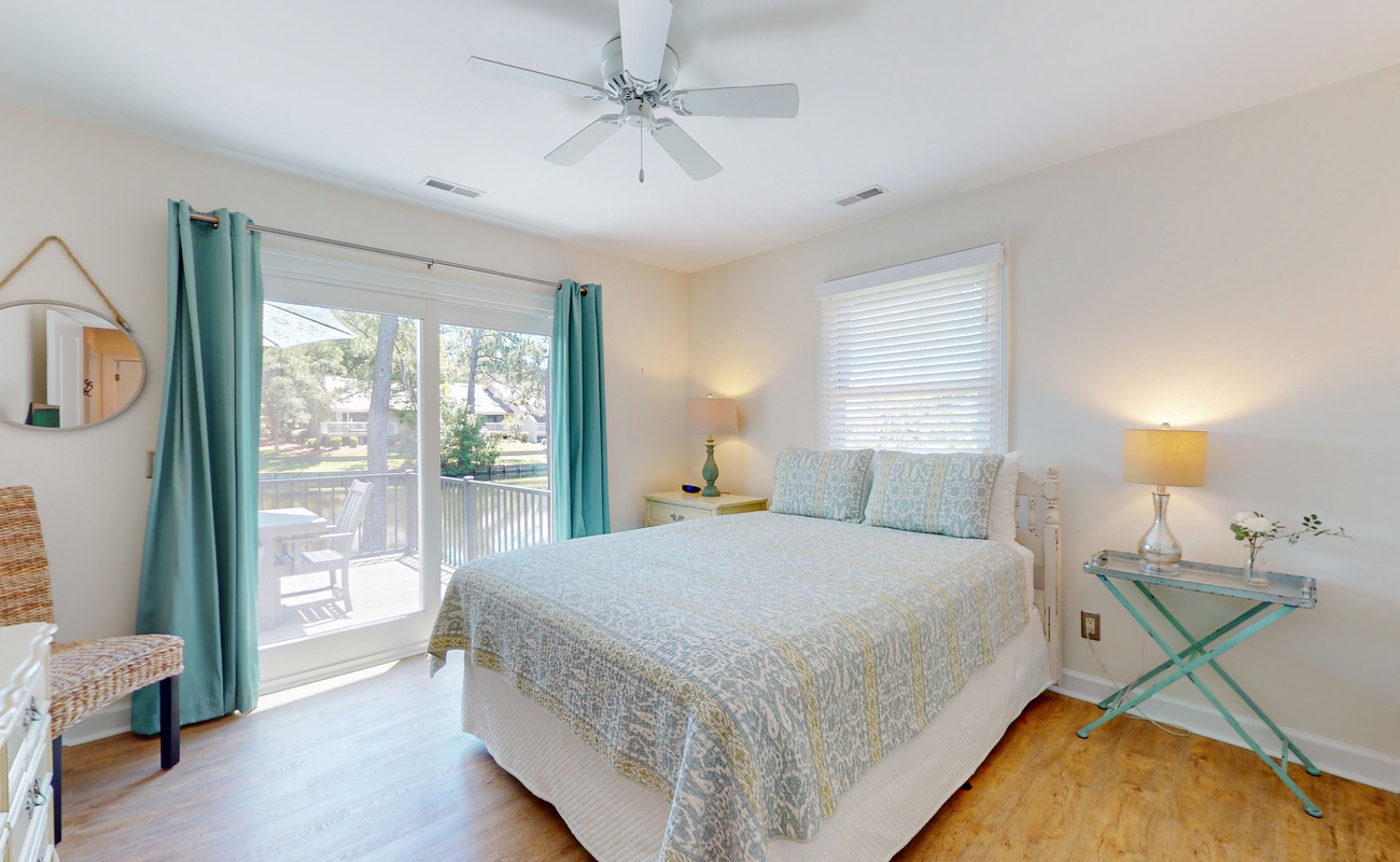 Drift off in your peaceful bedroom with soft coastal colors, cooling ceiling fan, and sunny balcony access for morning coffee.