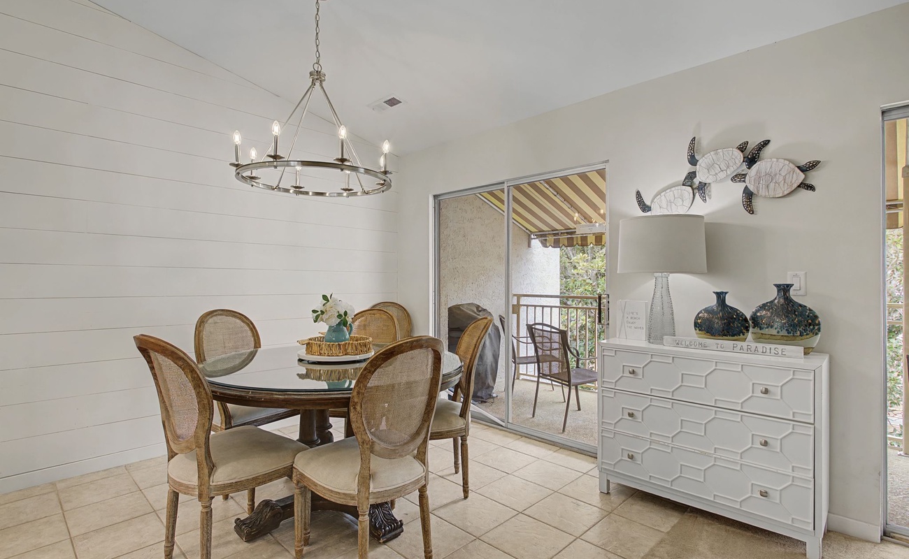 Gather around this elegant dining table where coastal charm meets comfort. The space opens to your private balcony for morning coffee.