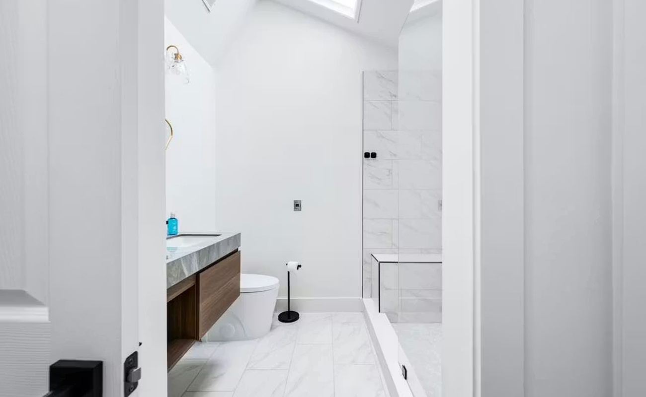 Unwind in your sleek, marble bathroom featuring a luxurious walk-in shower and modern fixtures bathed in natural light.