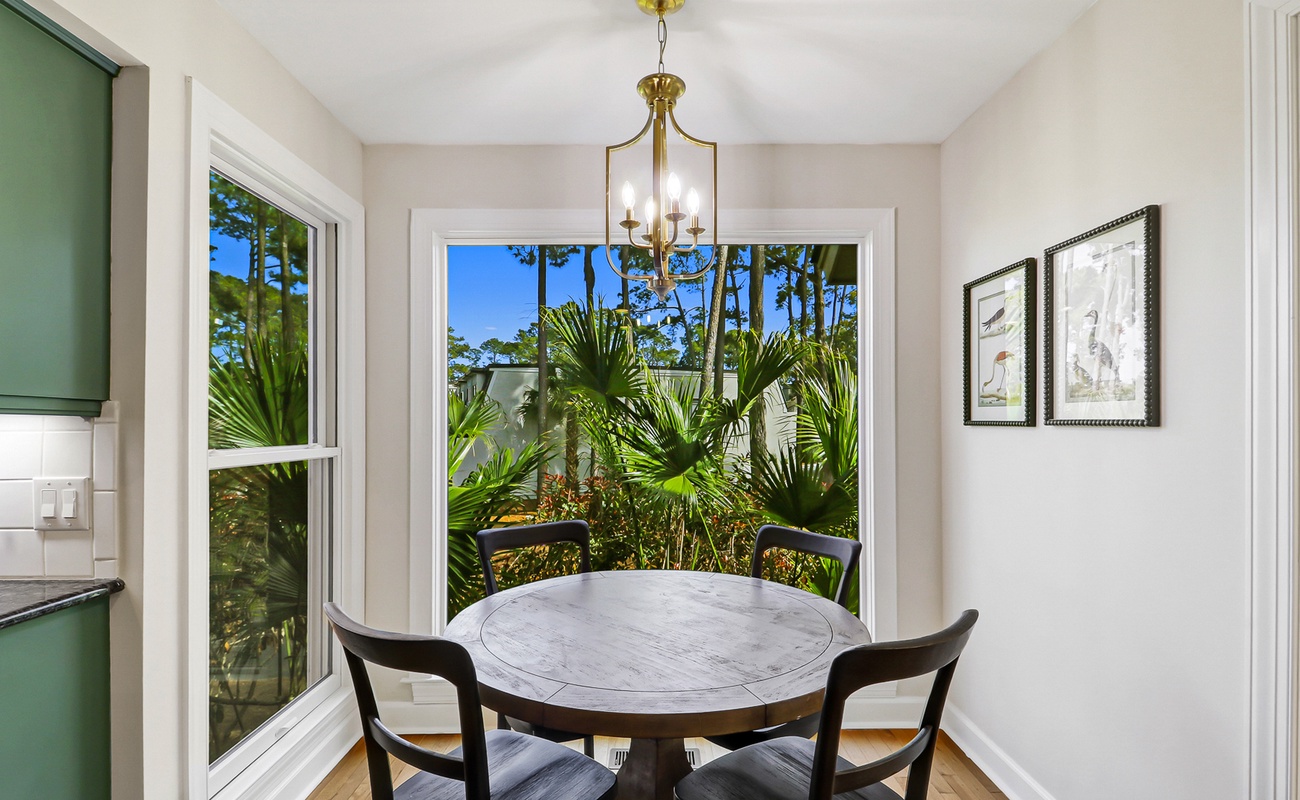 Enjoy intimate meals at your elegant round table, surrounded by tropical garden views through floor-to-ceiling windows that fill the space with natural light.