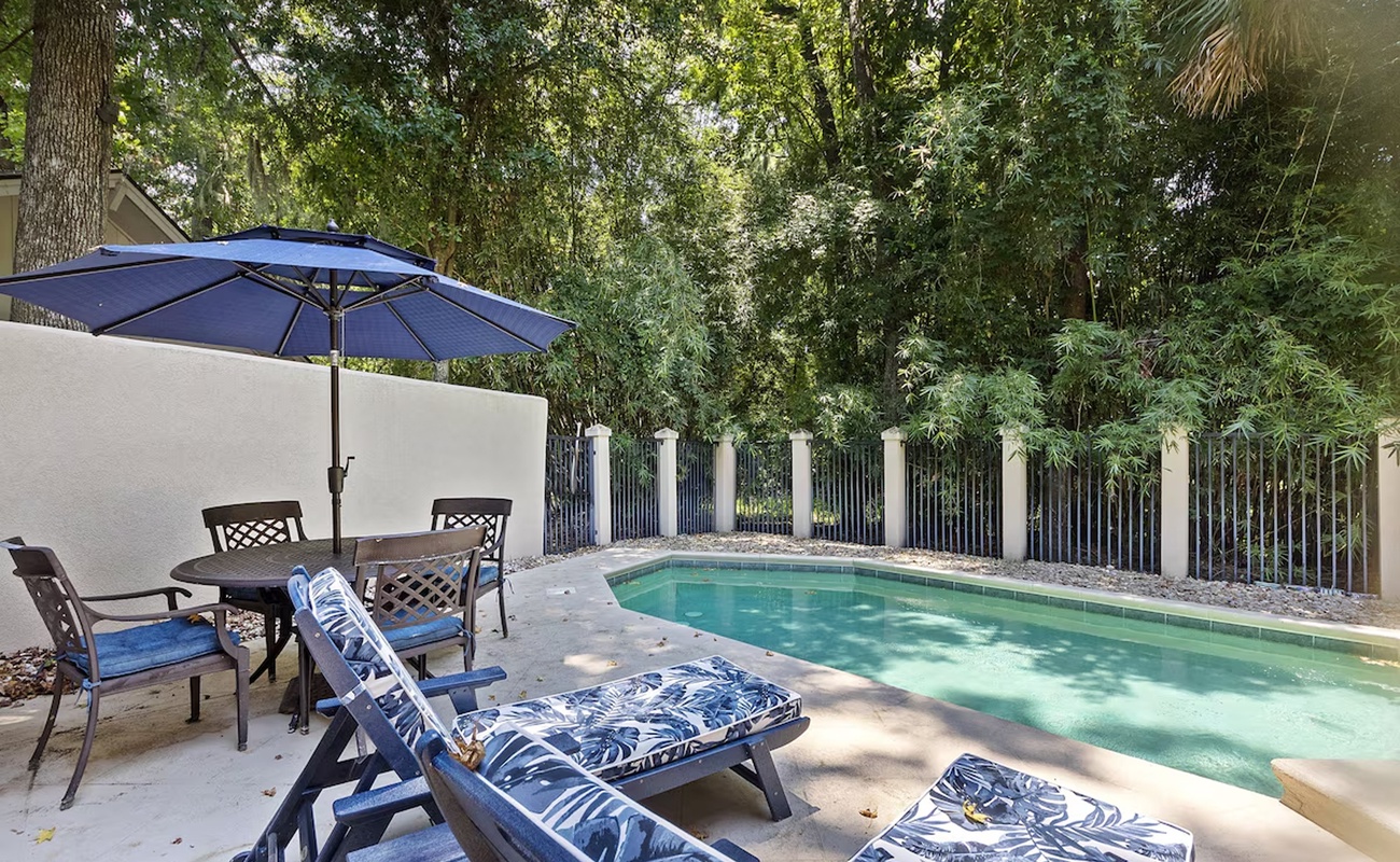 Dive into your private pool oasis, where tropical blue loungers and umbrella shade create your perfect poolside retreat.