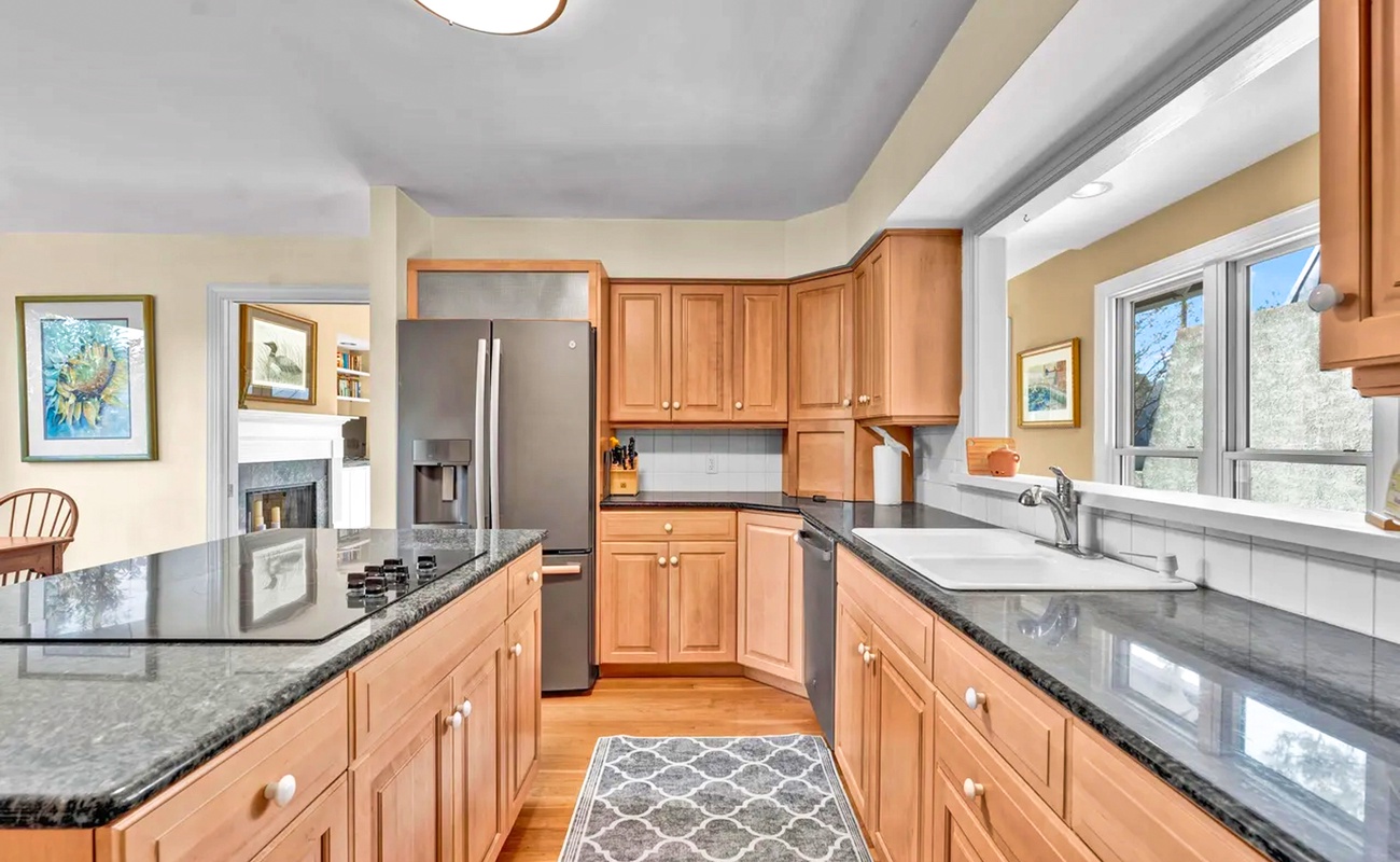 Your gourmet kitchen awaits with granite counters, stainless appliances, and warm wood cabinetry perfect for creating memorable meals together.