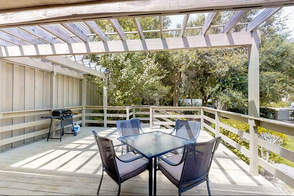 Your private deck offers peaceful dining under a pergola, with treetop views and BBQ ready for memorable outdoor meals.