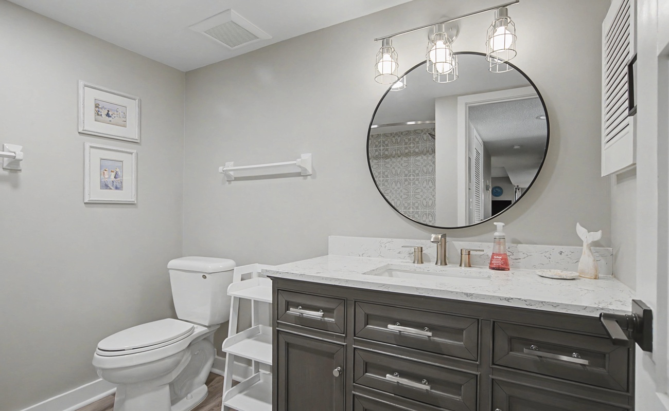 Step into your elegantly appointed bathroom featuring marble countertops, stylish lighting, and thoughtful coastal touches for your daily comfort.