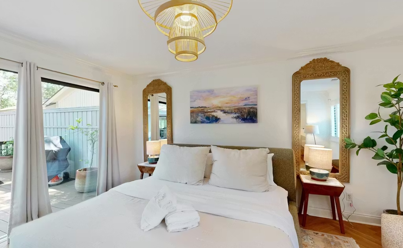 Sink into crisp white linens beneath golden pendant lights, where ornate mirrors and peaceful artwork create your serene sanctuary.