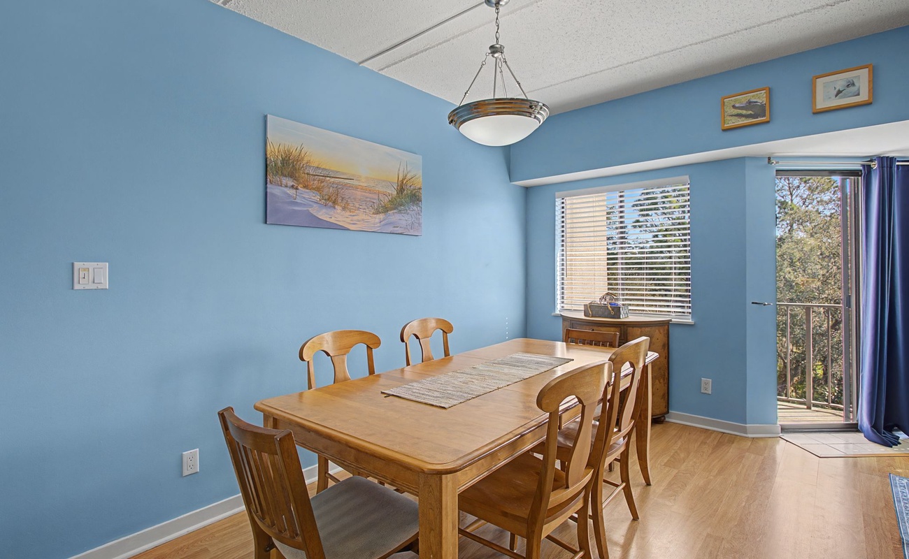 Gather around this warm dining table for memorable meals with your group, surrounded by soothing coastal artwork and natural light.