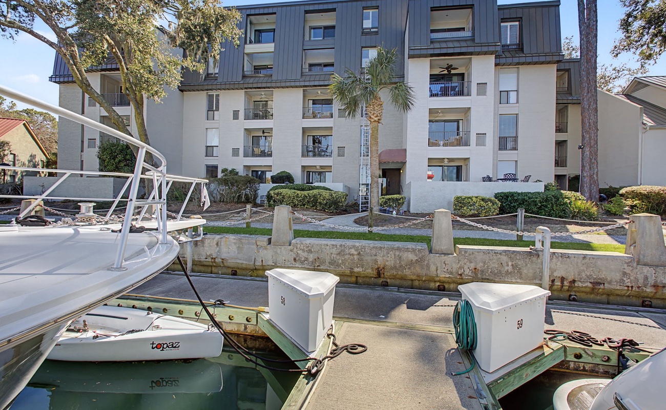 Modern waterfront property with private boat dock and tropical landscaping in a peaceful marina setting.