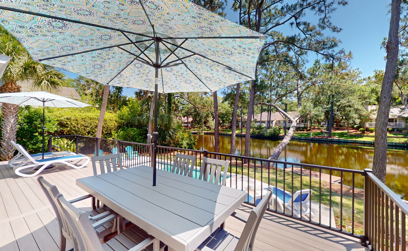 Sip your morning coffee at this waterfront dining table, shaded by a charming umbrella while watching the peaceful canal shimmer below.