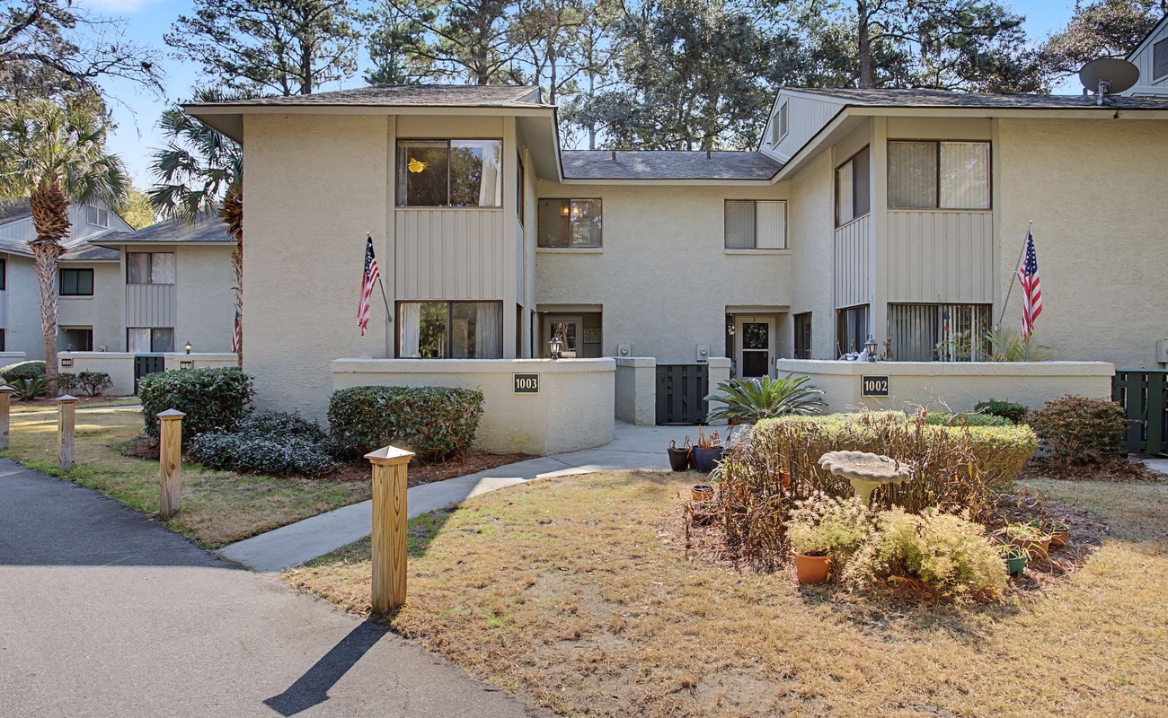 Modern townhome complex with landscaped grounds, mature trees, and convenient location in a peaceful residential community.