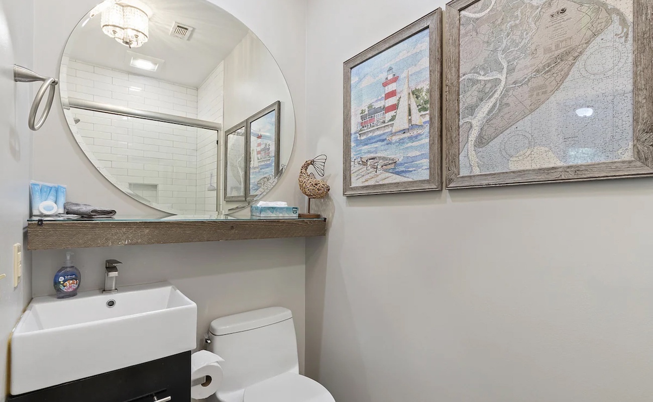 Your charming coastal bathroom features beautiful nautical artwork and modern amenities for a refreshing start to each day.