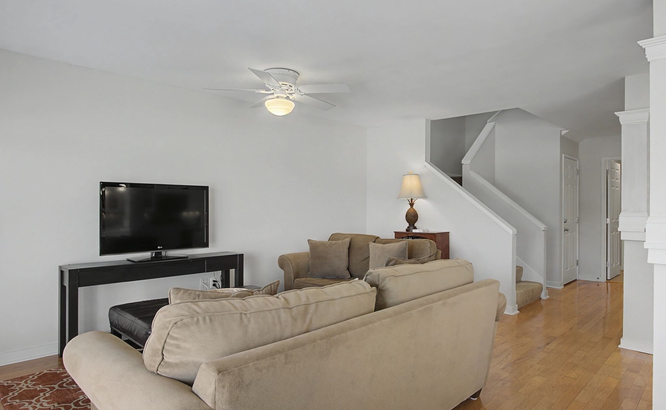 Sink into plush sofas in your spacious living room, where warm lighting and hardwood floors create the perfect atmosphere for relaxing evenings.