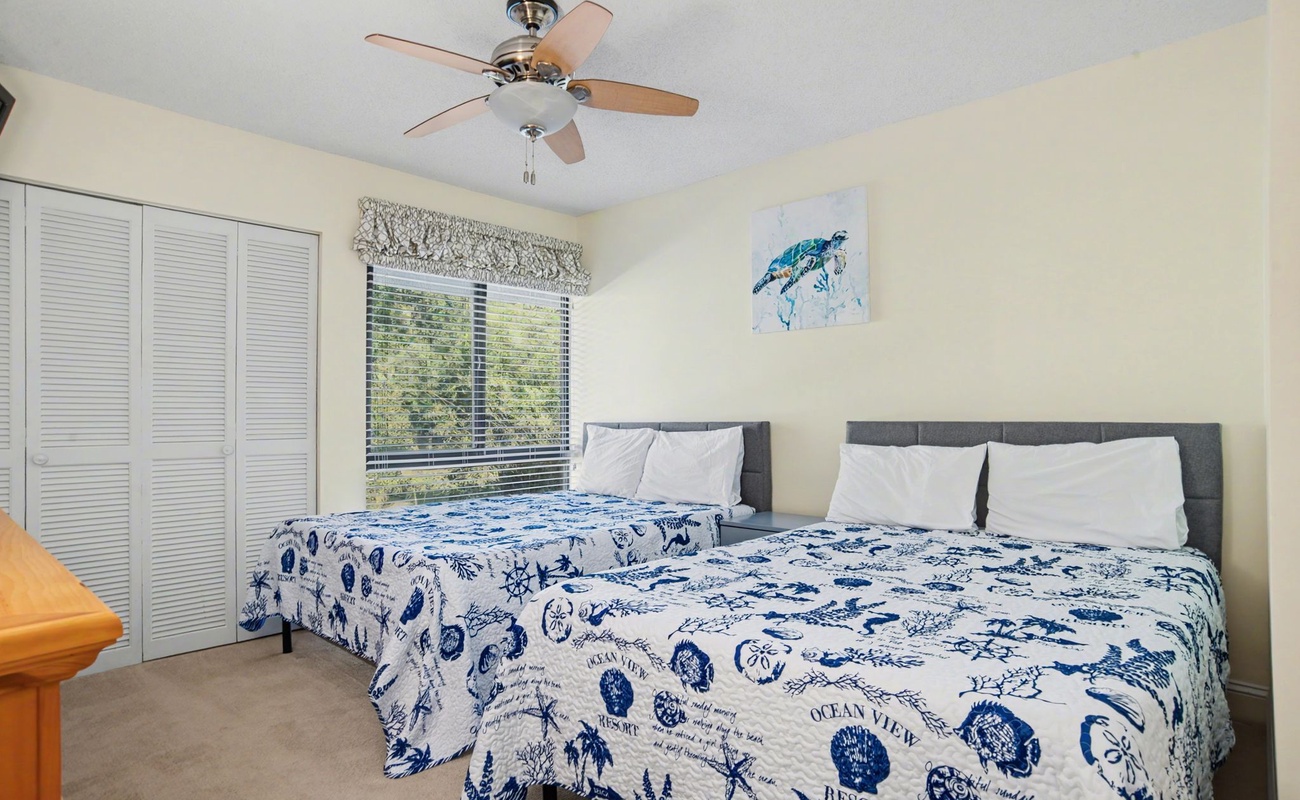 Drift off in your cheerful twin bedroom, where ocean-themed bedding and gentle ceiling fan breezes create the perfect coastal escape for restful nights.