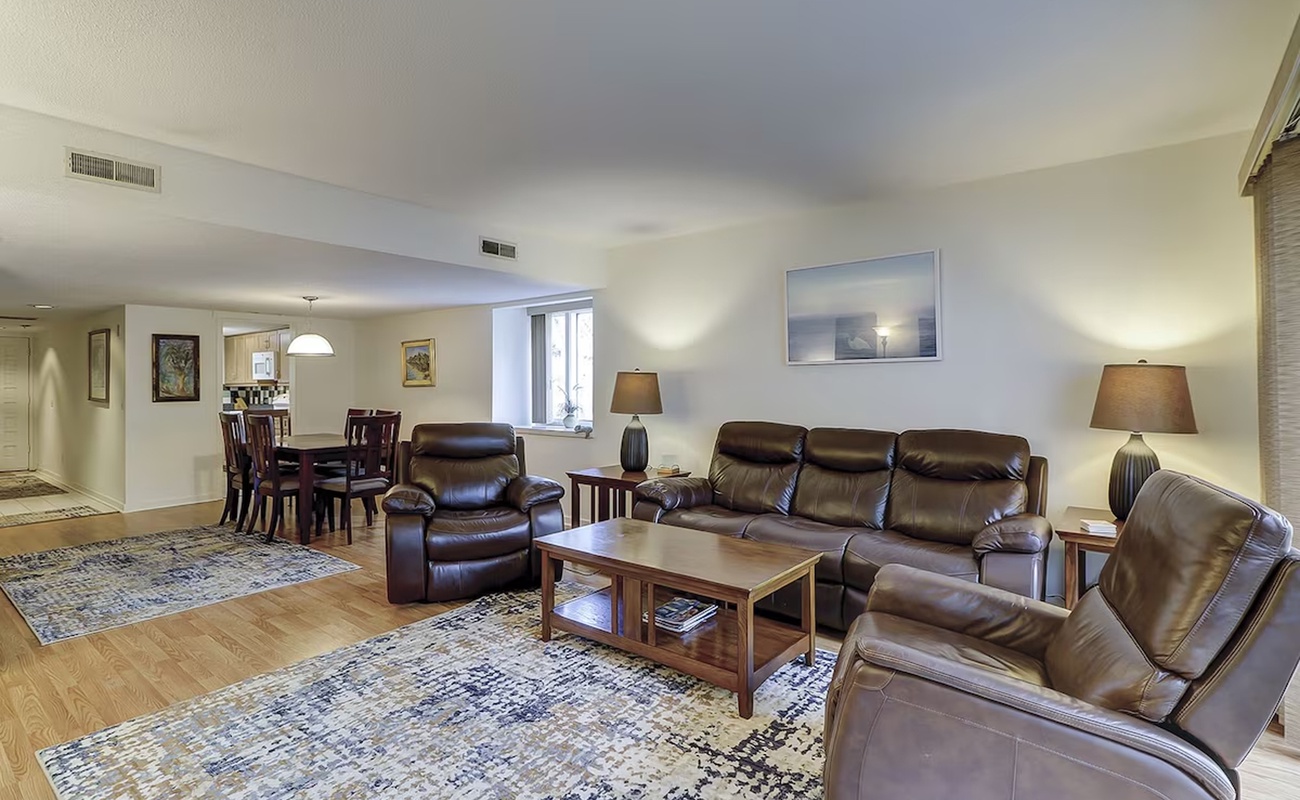 Relax in your spacious living room with plush leather seating and warm lighting, perfect for unwinding after exploring.