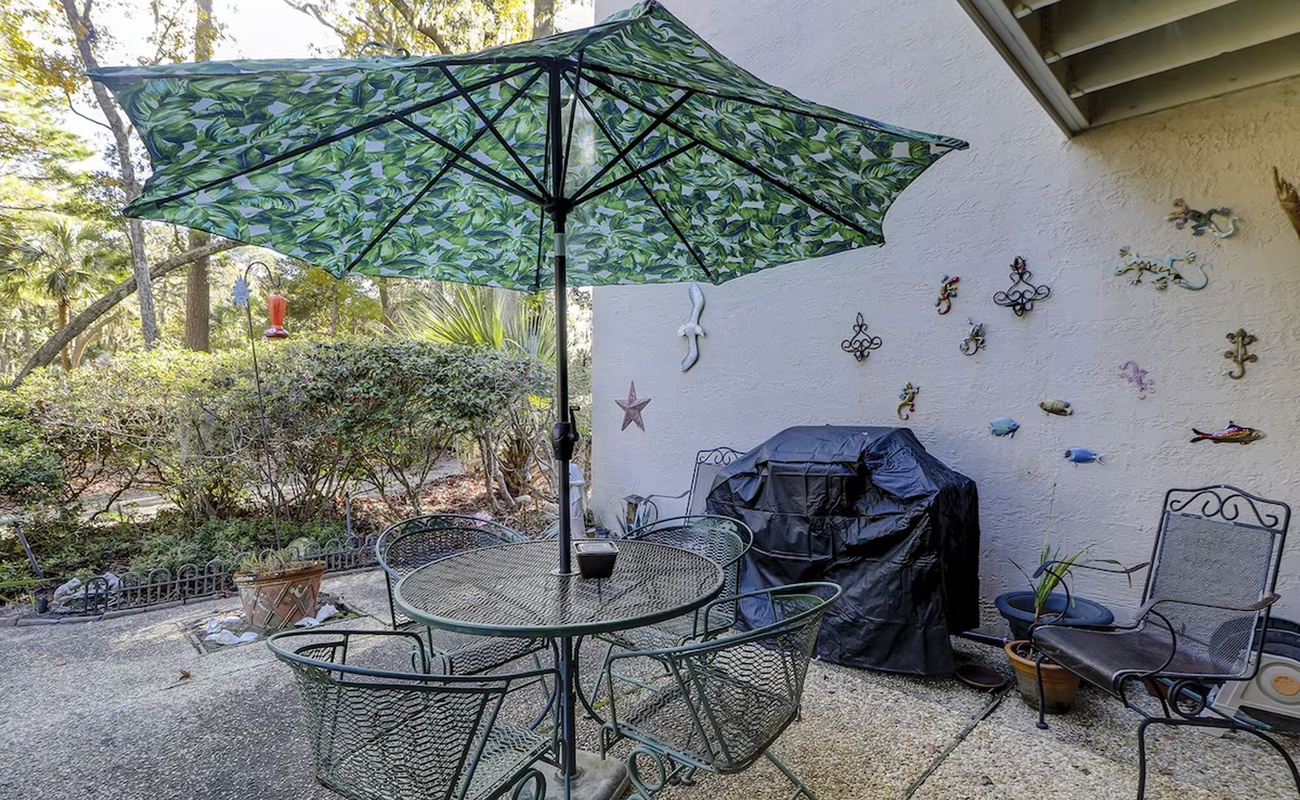 Your private patio features shaded outdoor dining with a grill for memorable meals and whimsical wall art.