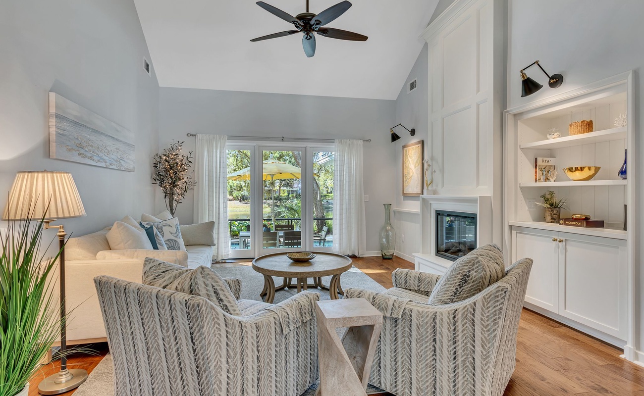 Sink into plush seating by your cozy fireplace, where coastal blues and thoughtful lighting create the perfect atmosphere for relaxing evenings.