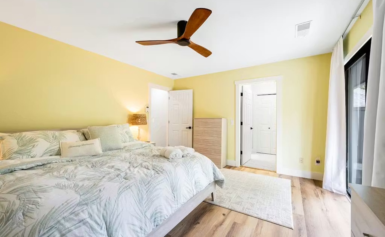 Wake up refreshed in this bright, airy bedroom with cheerful yellow walls and tropical bedding that sets a peaceful tone for your stay.