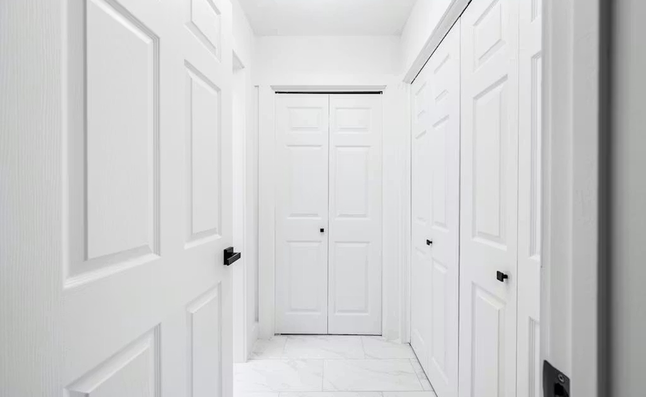 Step into your pristine hallway featuring elegant white doors and clean lines that create a sophisticated, welcoming atmosphere throughout your stay.