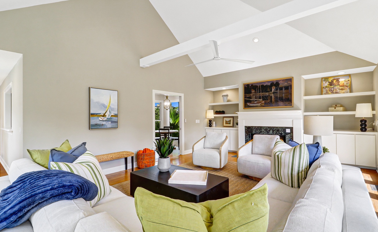 Relax in your spacious living room featuring vaulted ceilings, cozy fireplace, and comfortable seating perfect for gathering with loved ones.