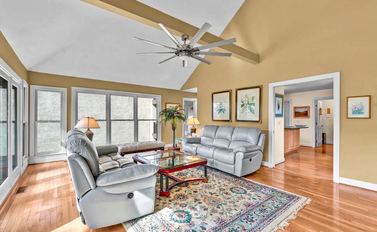 Relax in your spacious living room with vaulted ceilings, comfortable leather seating, and beautiful hardwood floors throughout.