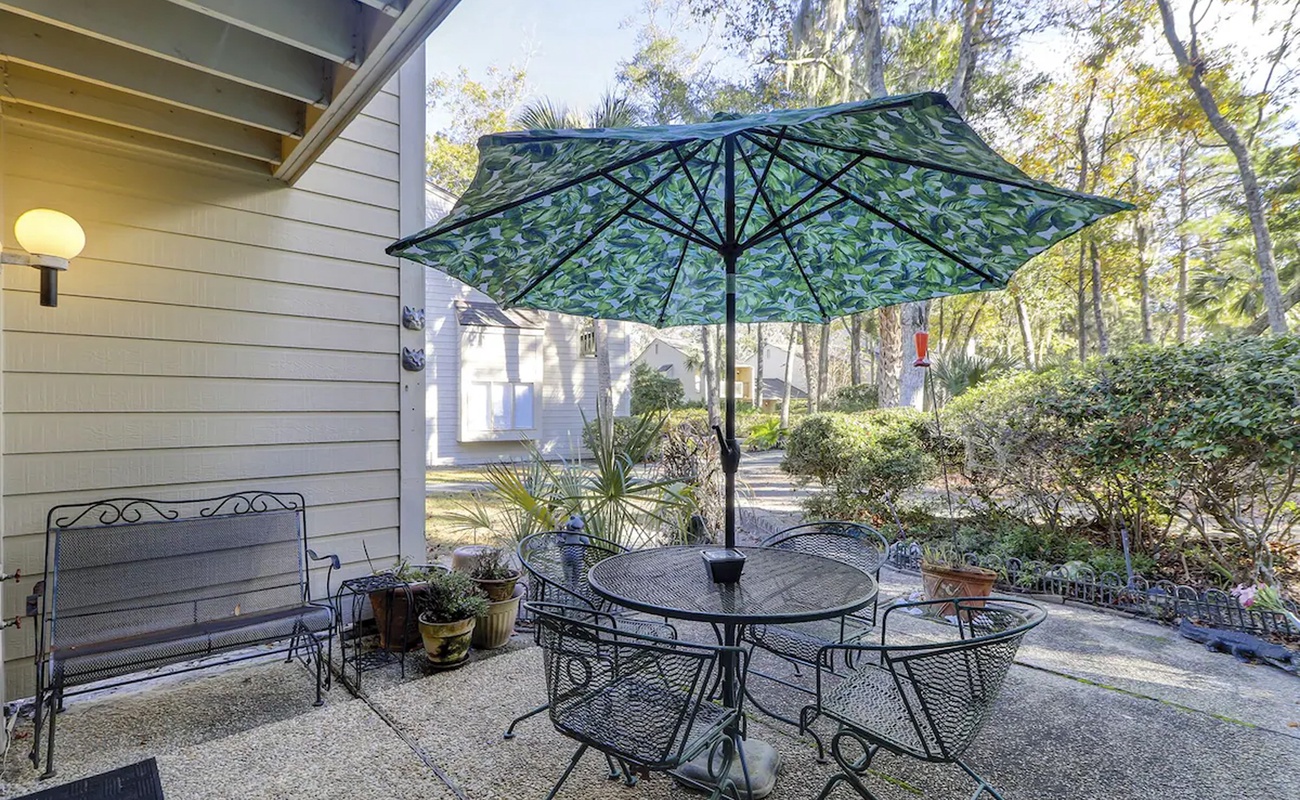 Relax on your private patio with leafy umbrella shade, perfect for morning coffee or evening conversations surrounded by lush gardens.