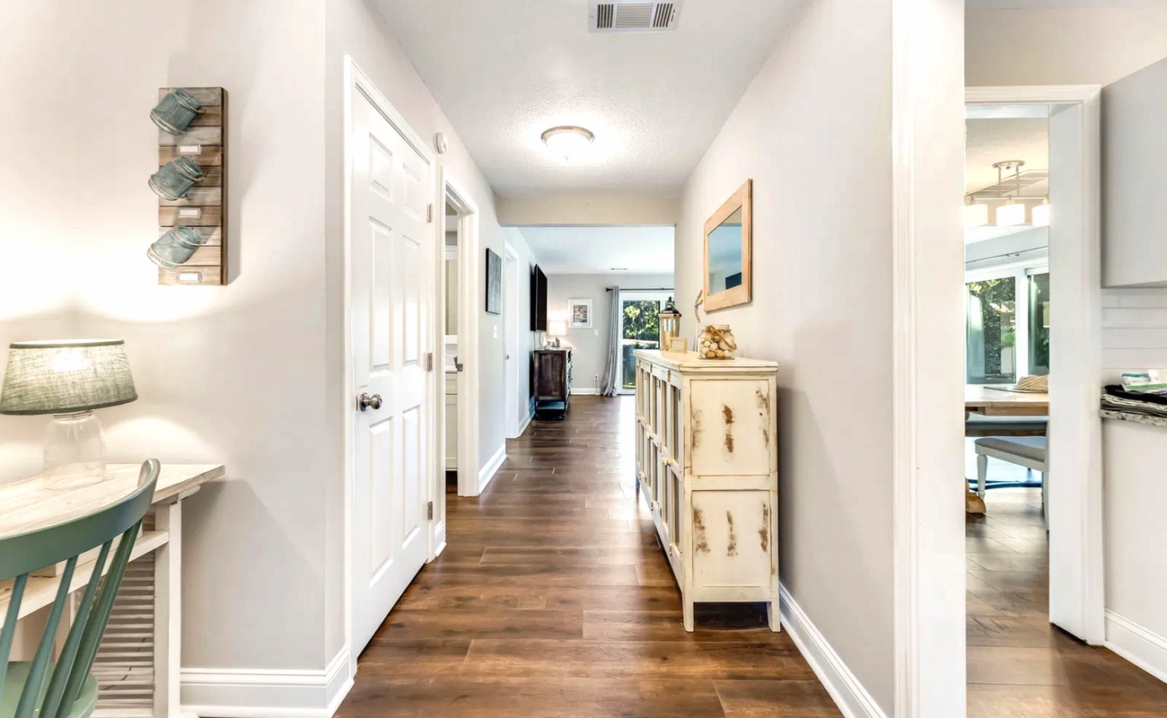 Step into your welcoming hallway where warm wood floors and thoughtful coastal touches create an instantly relaxing atmosphere for your stay.